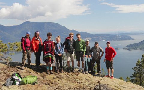 Students_smiling_together_with_stunning_ocean_and_mountain_views_behind_them