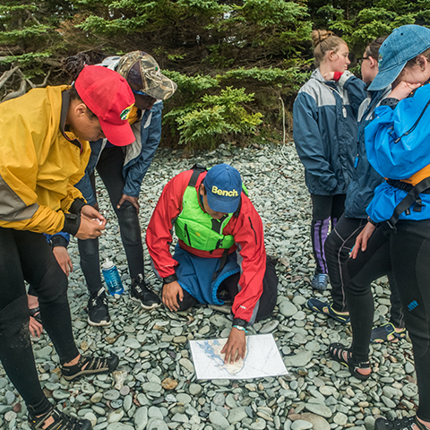 Six people gathered around a map