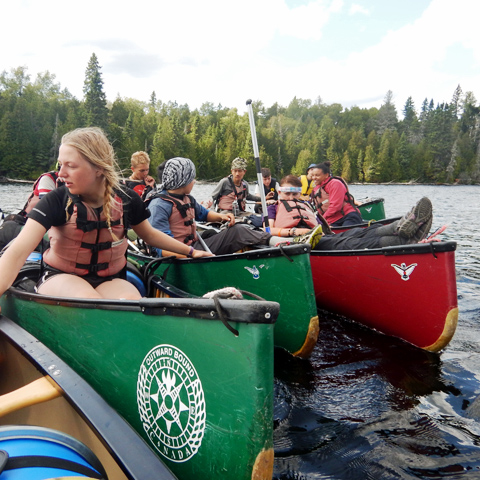 group-of-participants-holding-onto-canoes