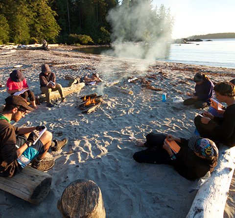 teens journaling a beach at sunset