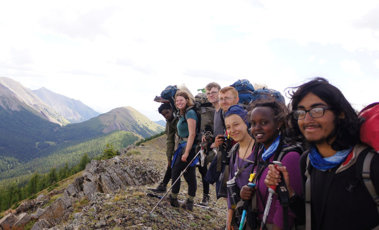 Group of people smiling on top of a mountain