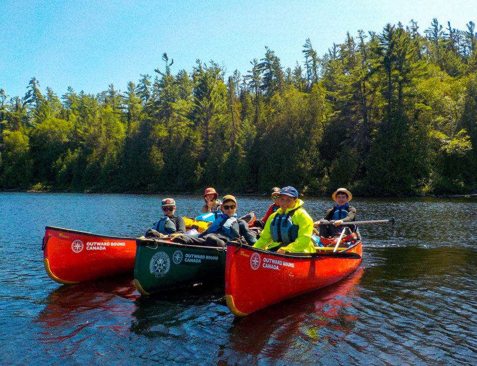 Image of a group of youth in canoes on a lake