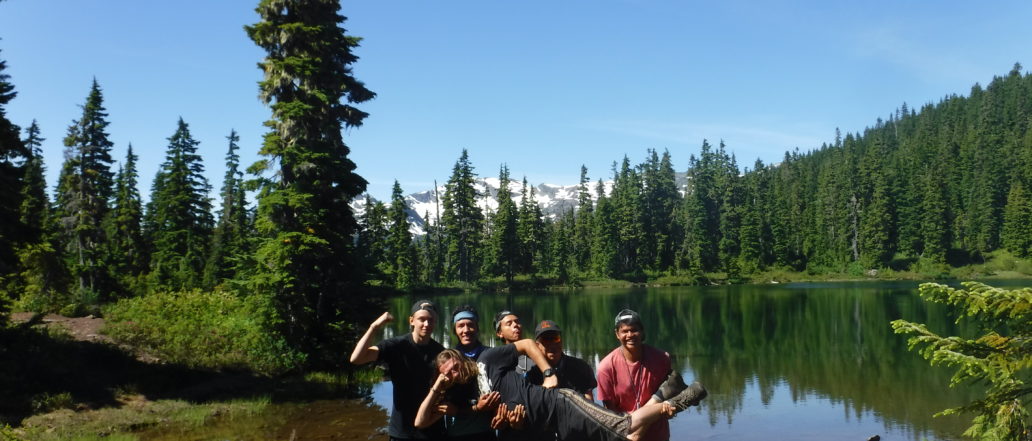 Group of youth lifting up instructor