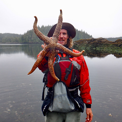Image of a young adult holding up a large starfish