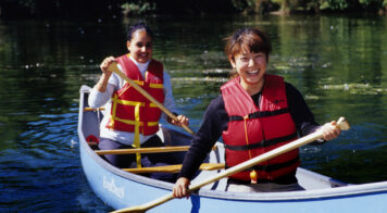 two teens canoeing on flat water