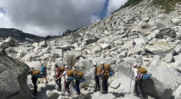 teens hiking rocks in backpacking gear