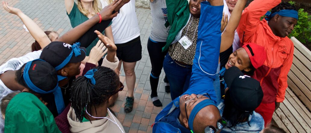 A group of teens with their hands raised after doing a cheer