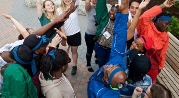 A group of teens with their hands raised after doing a cheer