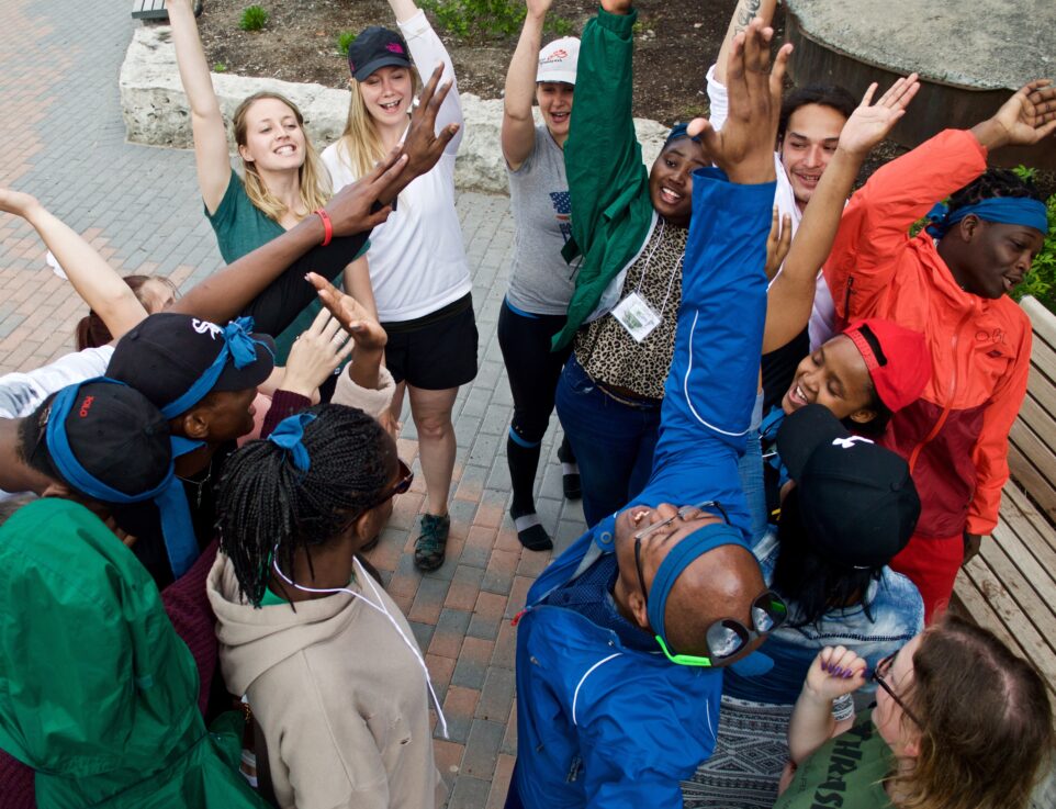 A group of teens with their hands raised after doing a cheer