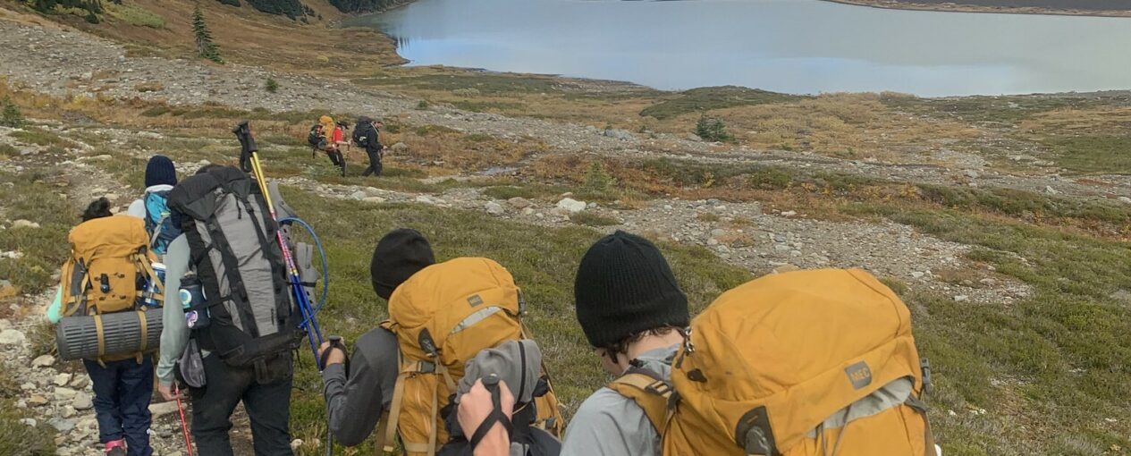 teens hiking on mountain with backpacks