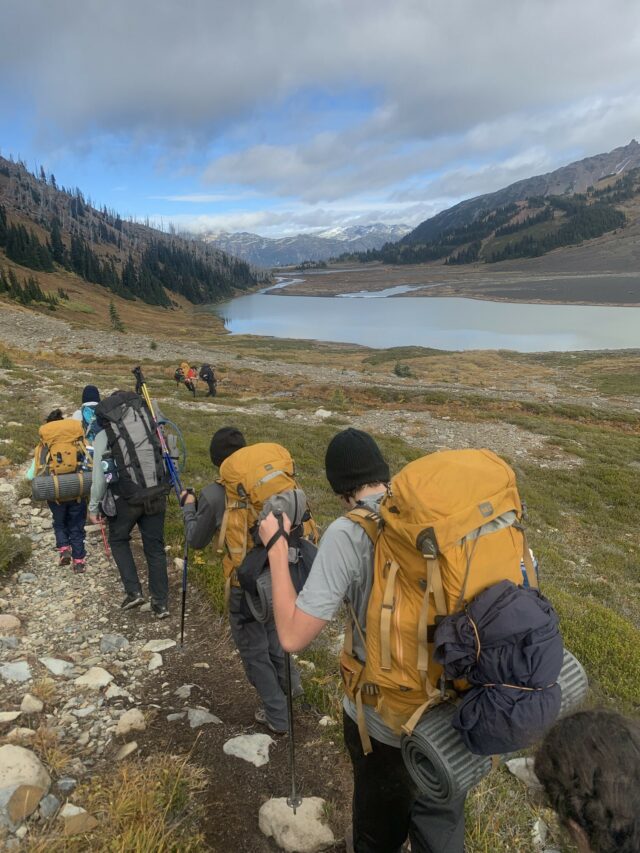 teens hiking on mountain with backpacks