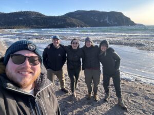 teens taking a selfie smiling on beach with mountain background