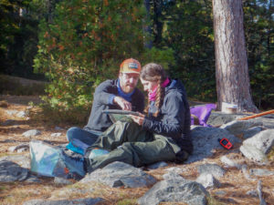 Image of an instructor trainer sitting next to a student and pointing at a map.