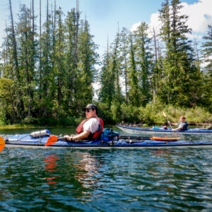 boy paddling a canoe on a lake