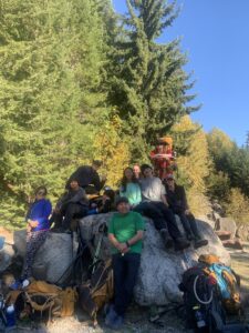 teens sitting on a rock smiling