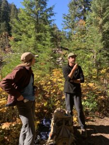 two teens smiling in the forest 