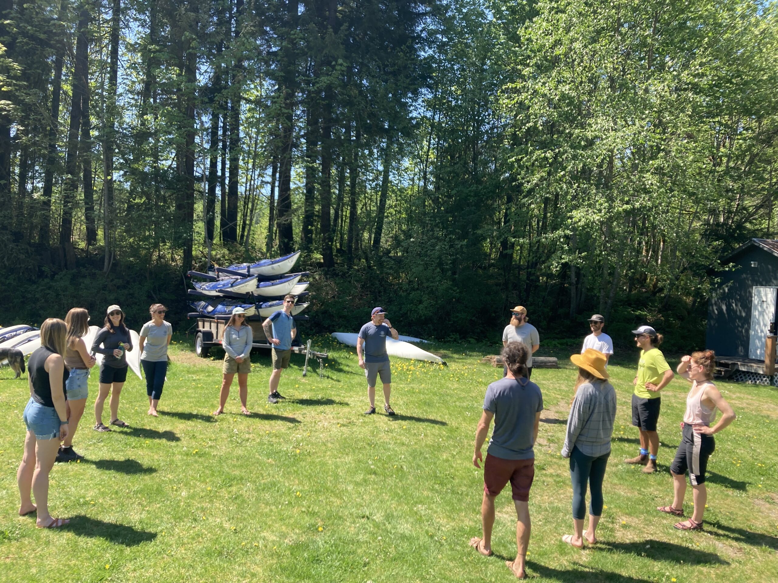 a group of adults standing in a circle in a forest field