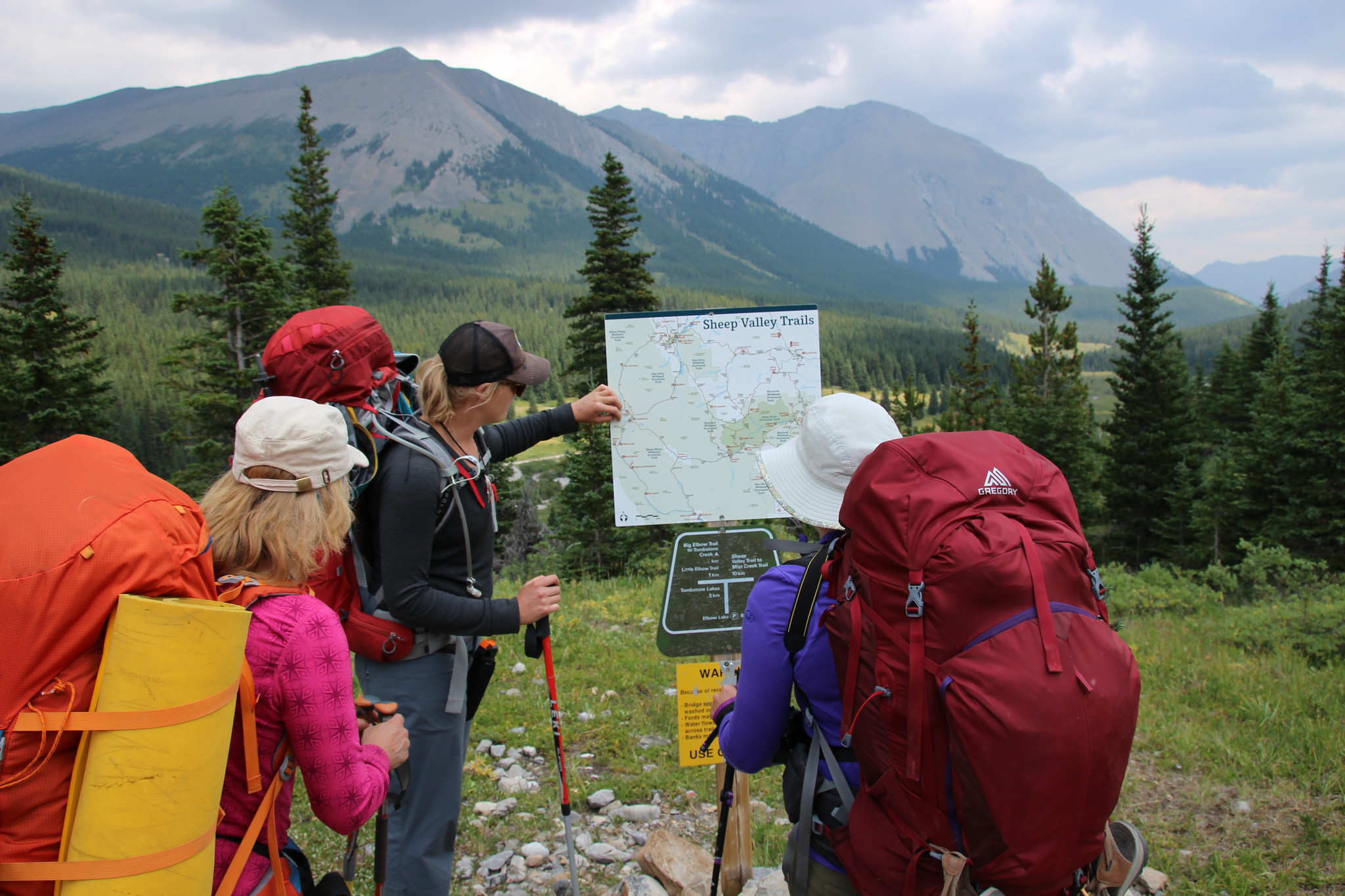 A group of young OBC participants look at a map during a wilderness trail