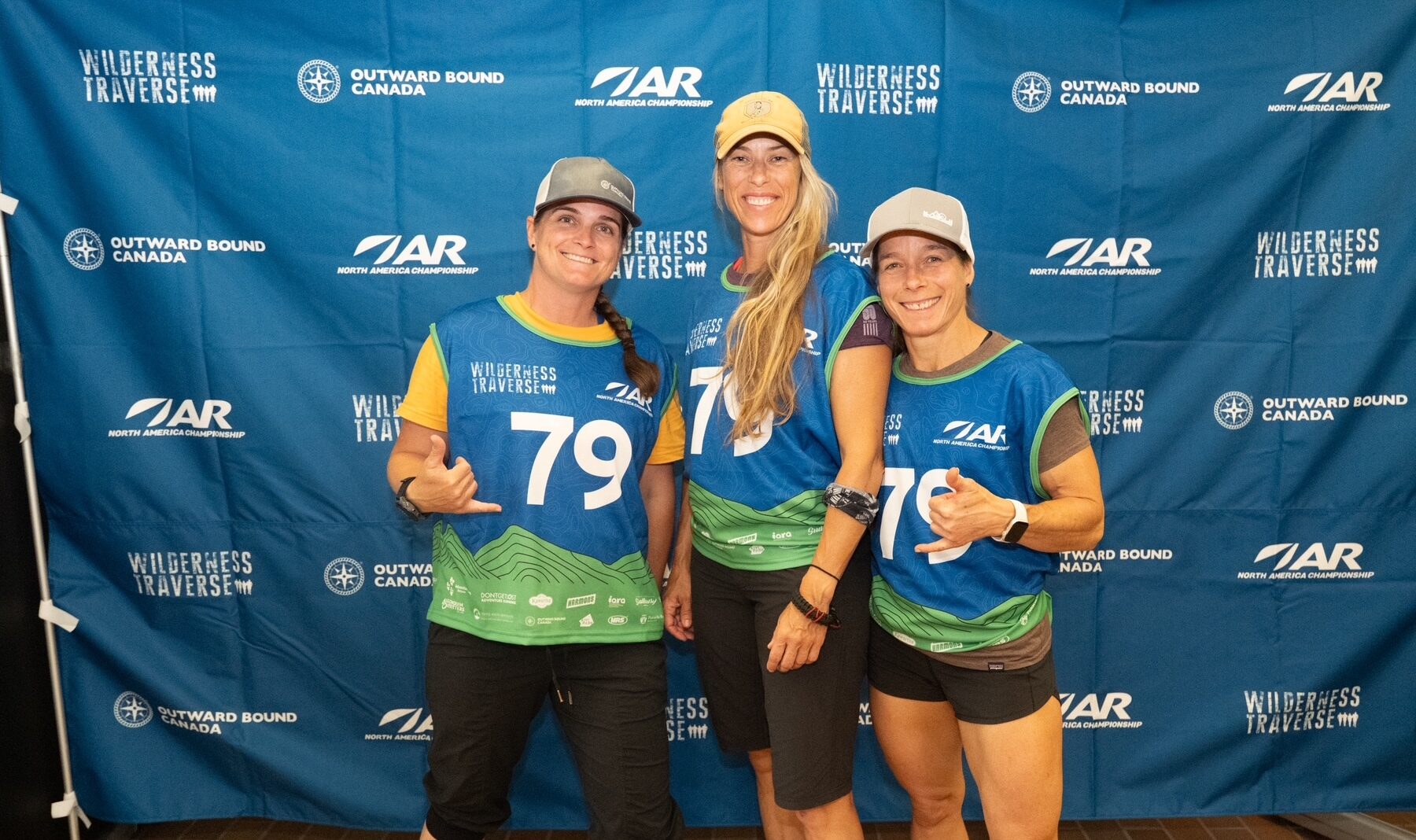 Three members of The Breakfast Club posing together in their Wilderness Traverse race jerseys.