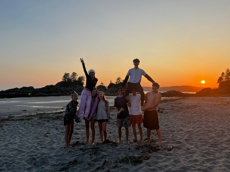 OBC participants standing together on a beach at sunset during their Sea Kayaking & Surfing course in 2024.